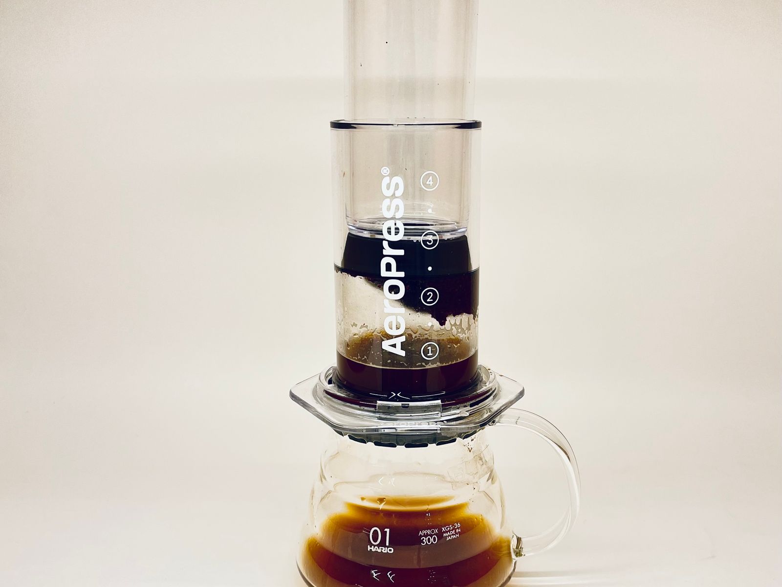 AeroPress coffee maker brewing fresh coffee into a glass carafe