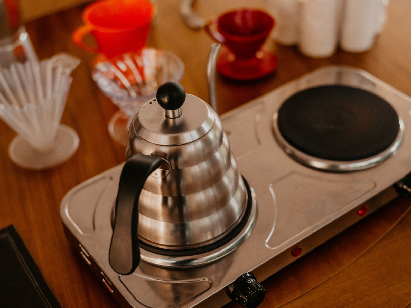 A brewing setup with a stainless steel kettle on a coffee bar