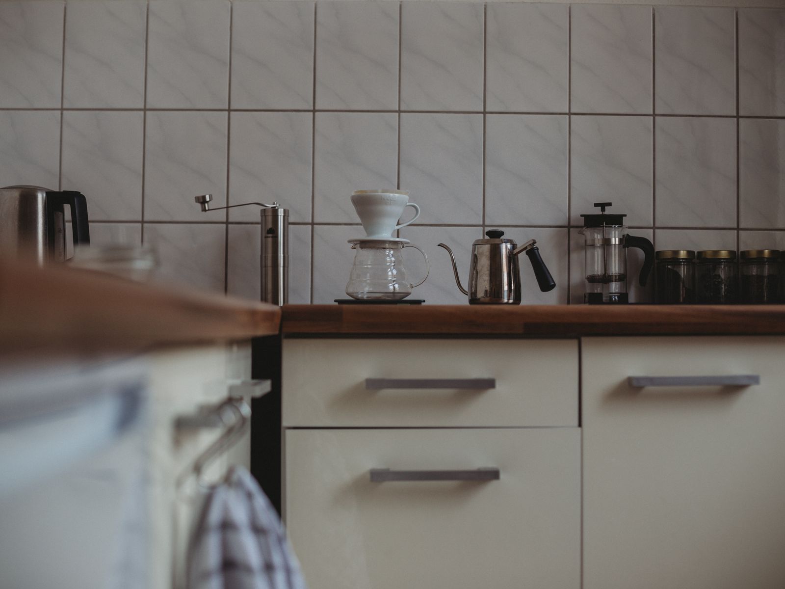 A tidy coffee station with brewer, grinder and tools in a small space