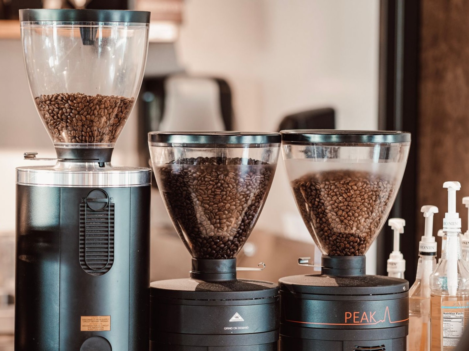 Electric coffee grinder filled with roasted beans on a counter