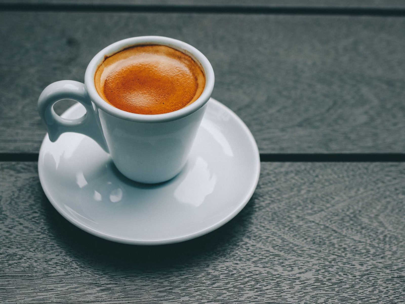 Espresso shot in a porcelain cup, the base for a flat white at home