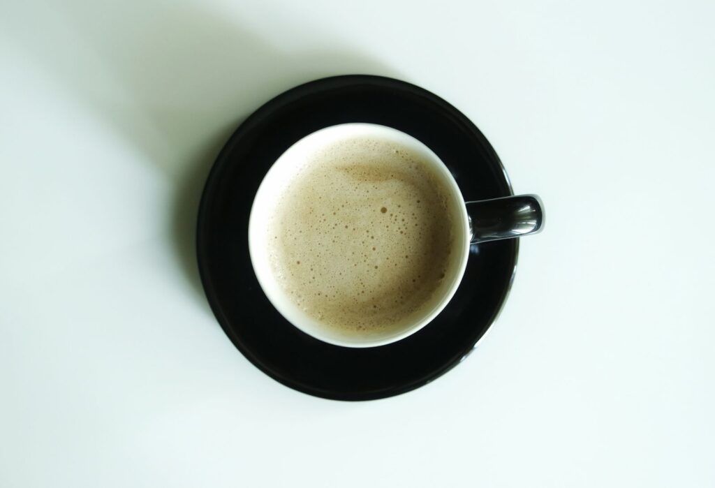 A creamy flat white at home served in a black cup