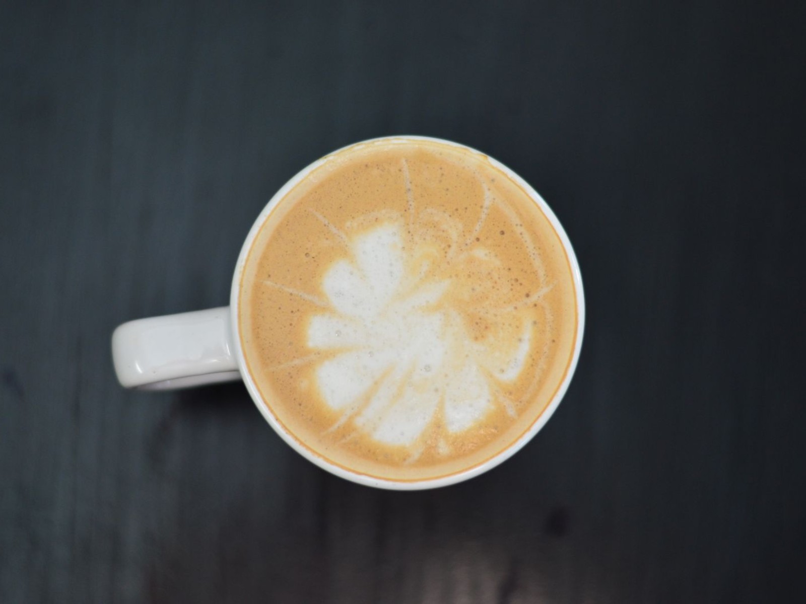 Cappuccino topped with foamed milk and a latte art pattern