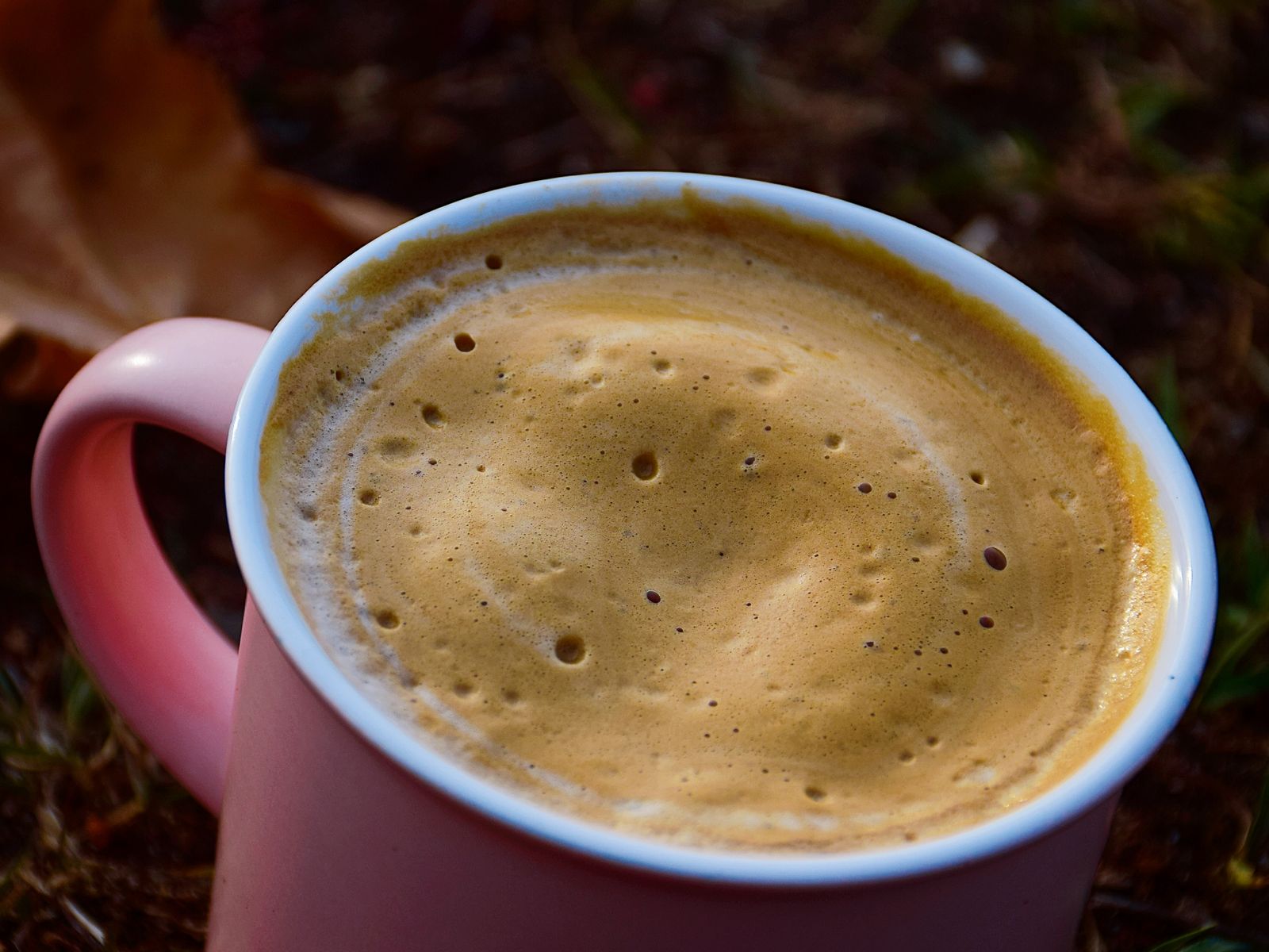 Steaming mug of coffee topped with foamy frothed milk