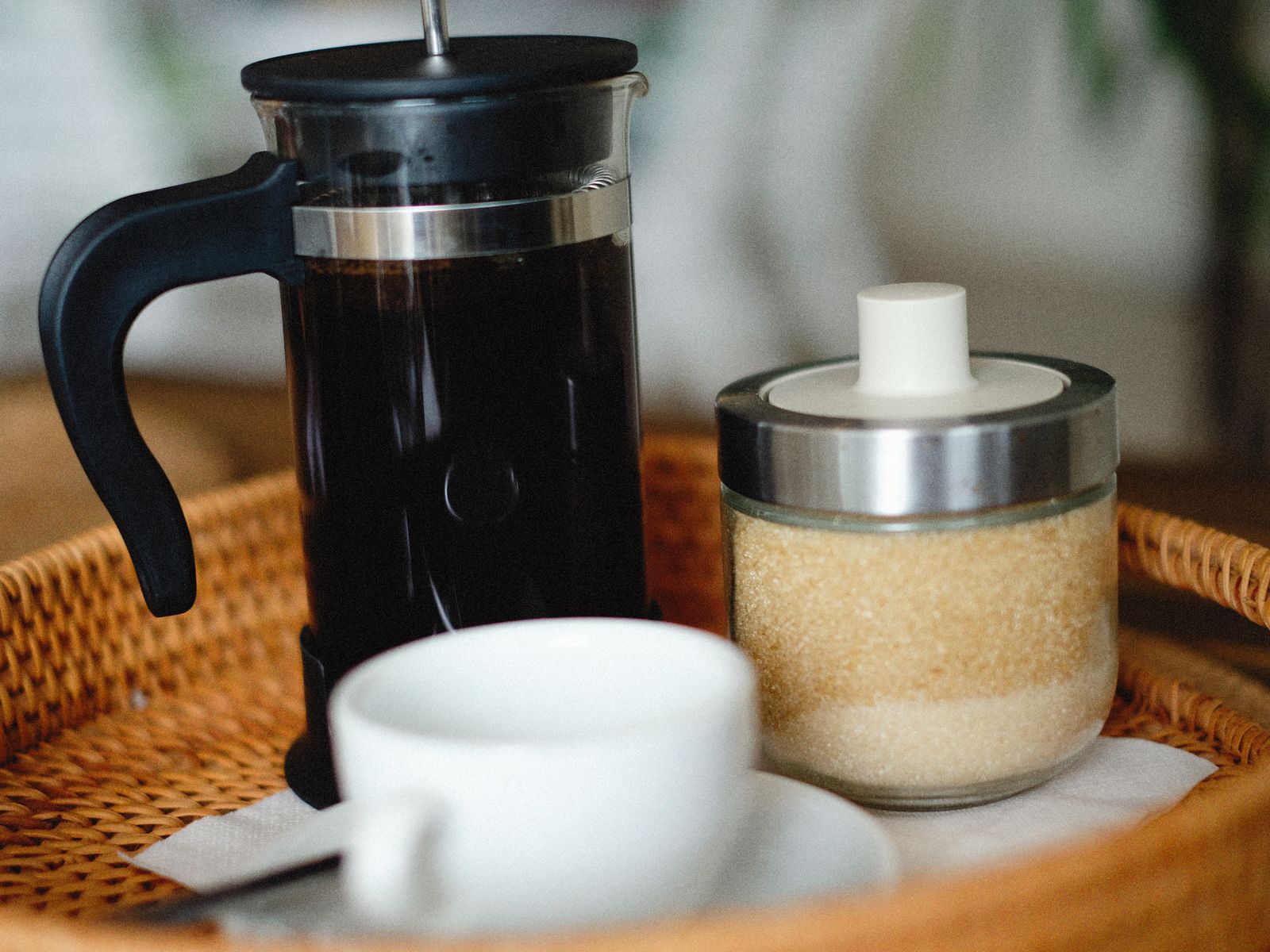 French press beside a freshly poured cup of coffee