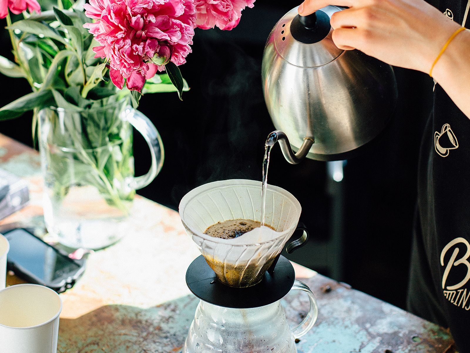 Person using a budget gooseneck kettle for pour-over coffee