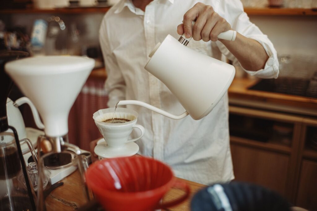 Barista pouring coffee with a gooseneck kettle