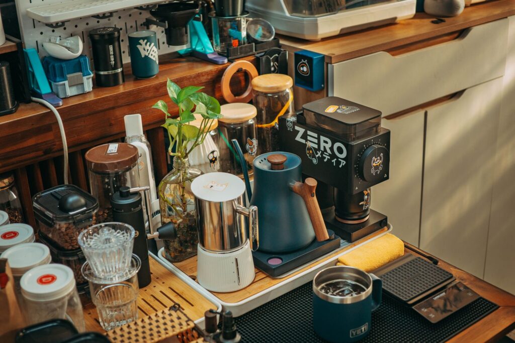 A home coffee bar setup with grinder, mugs, and brewing gear