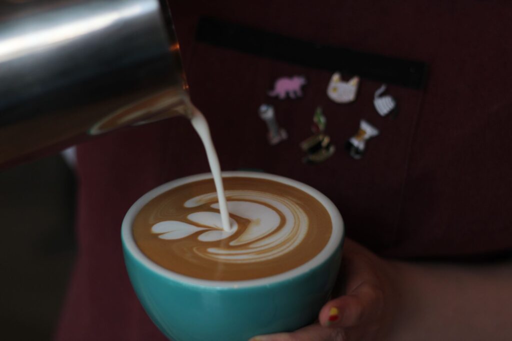 Milk being poured into a cup, where latte art mistakes often happen