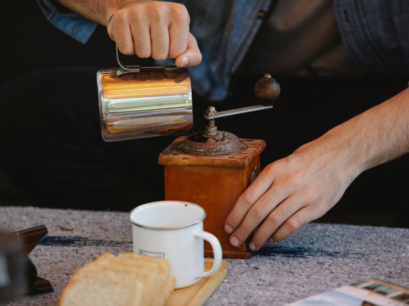 Hands using a manual coffee grinder, a key player in the manual vs electric grinders debate