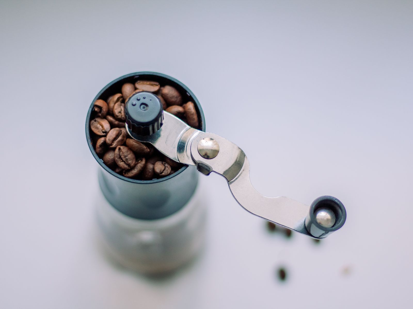 Top view of a manual coffee grinder filled with beans