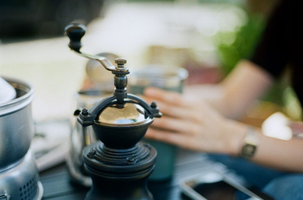 Manual coffee grinder in use, part of a manual vs electric grinders comparison