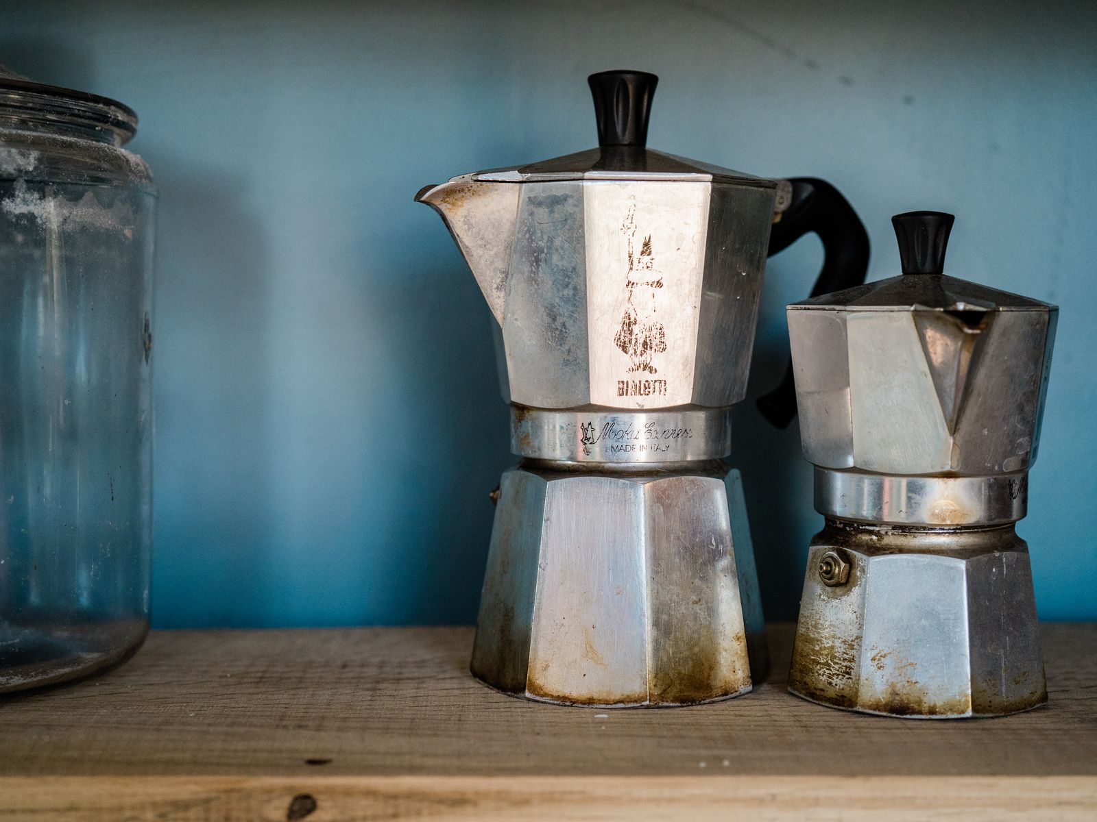 Classic moka pots on a wooden shelf, an affordable coffee tool