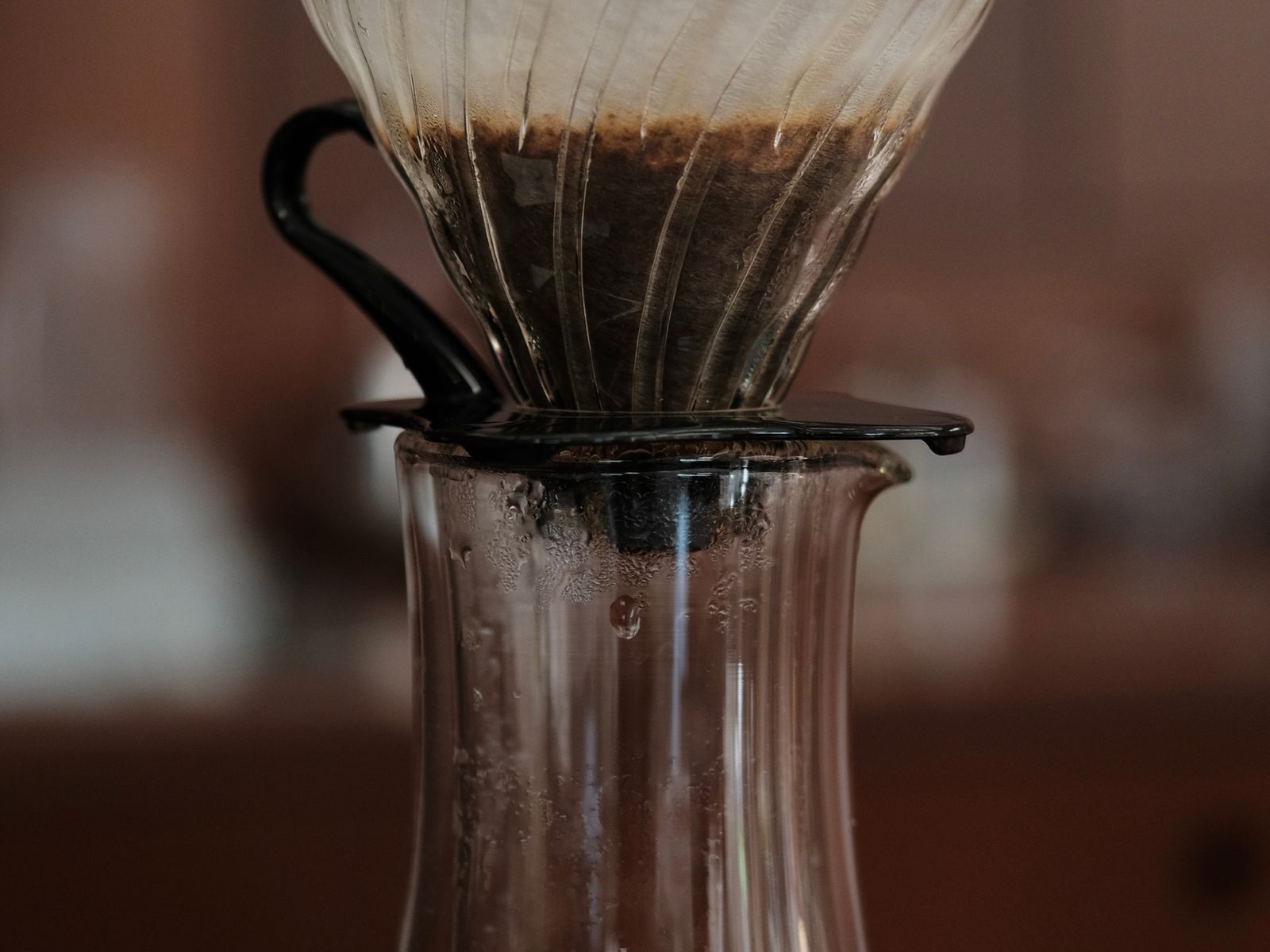 Pour-over coffee setup with a glass dripper and carafe on a counter
