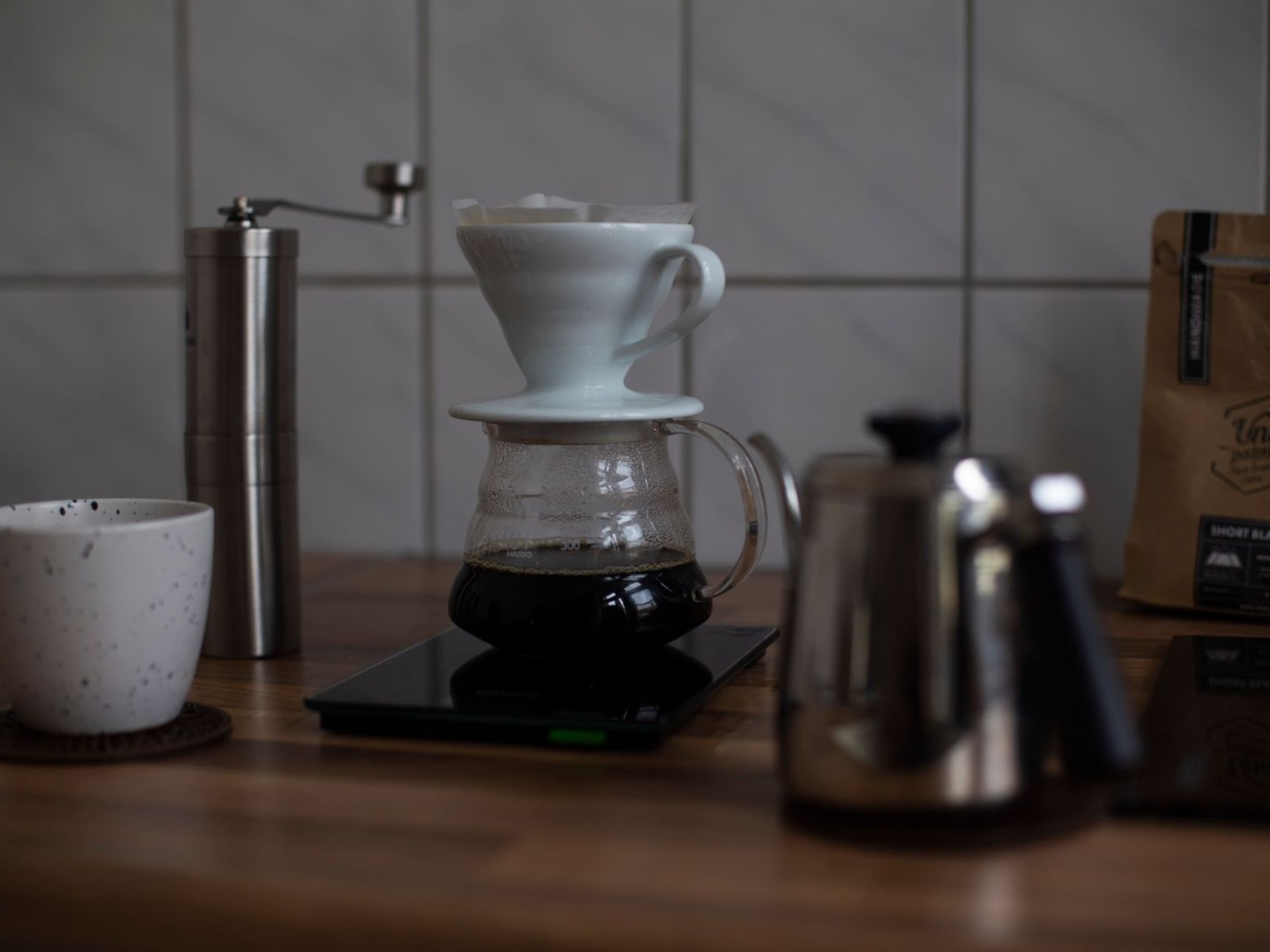 Pour-over dripper and ceramic cup on a wooden table