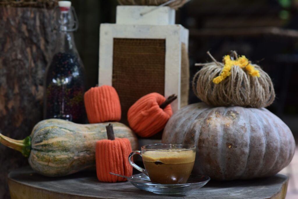 A cozy autumn pumpkin spice latte with a pumpkin and fall decor