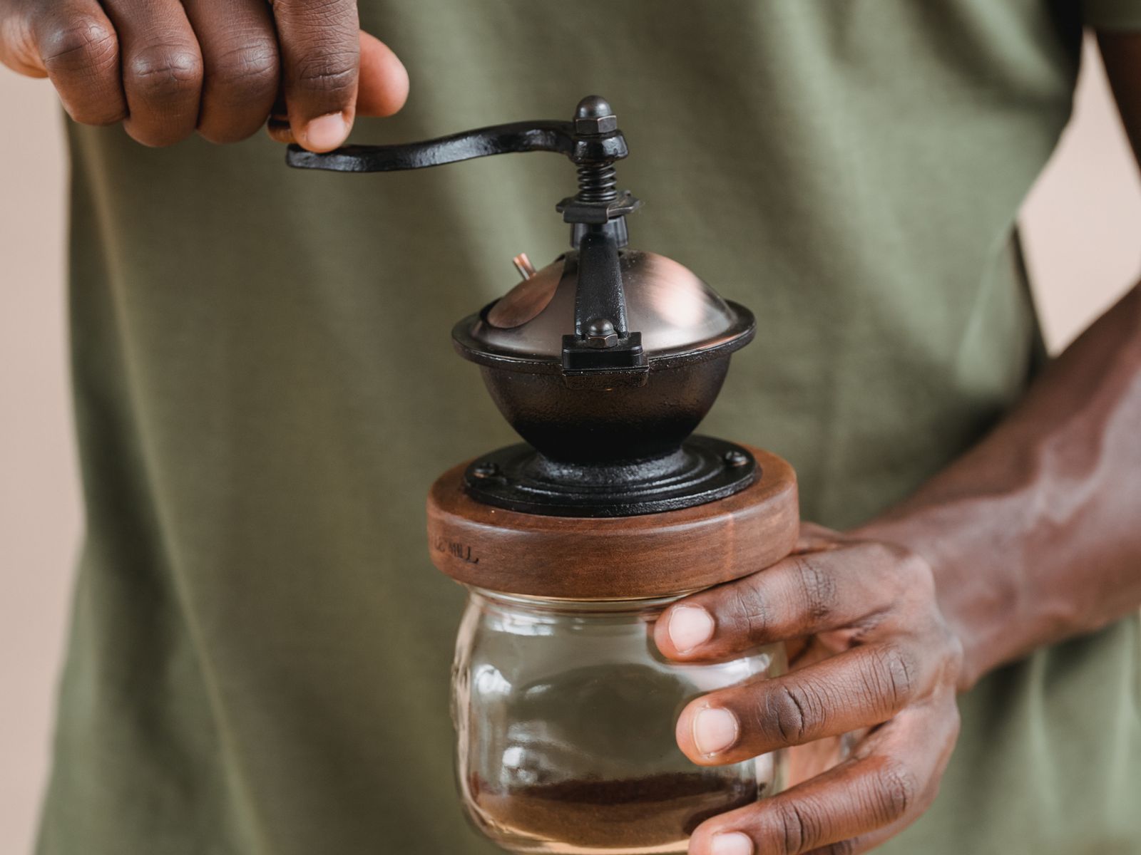 Person using a manual burr coffee grinder