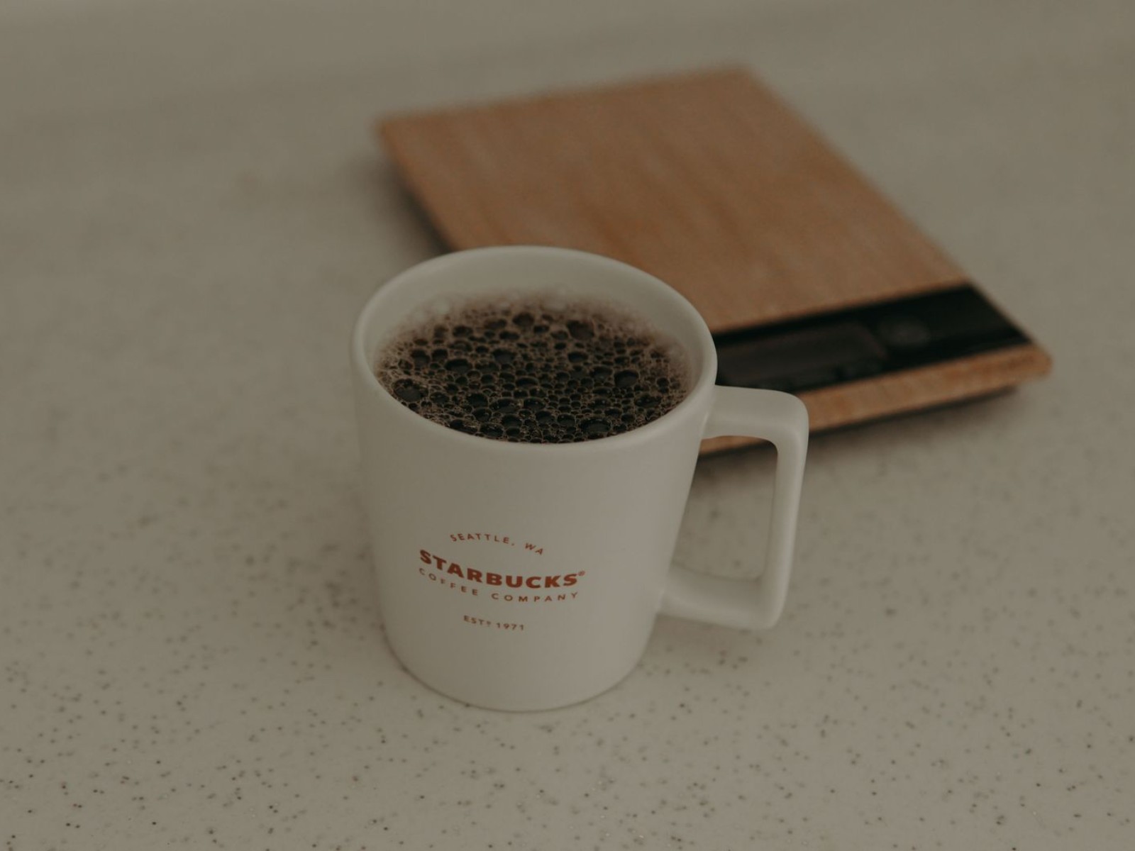 Coffee mug beside a kitchen scale used to weigh coffee grounds