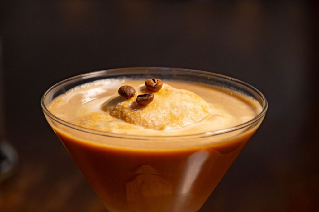 An affogato at home with espresso poured over ice cream and coffee beans on top