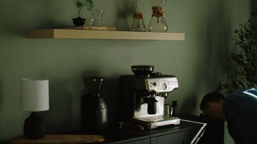 A compact coffee corner using floating shelves for jars and mugs in a tiny kitchen