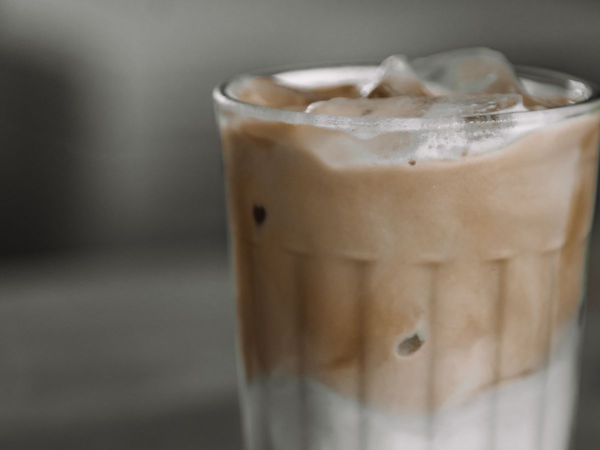 Cold brew coffee concentrate poured over ice cubes in a clear glass