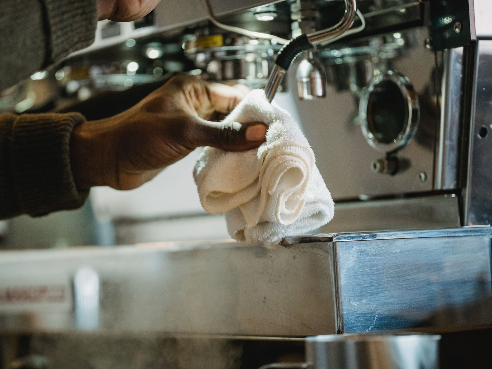 Wiping down and descaling a coffee machine to remove mineral buildup