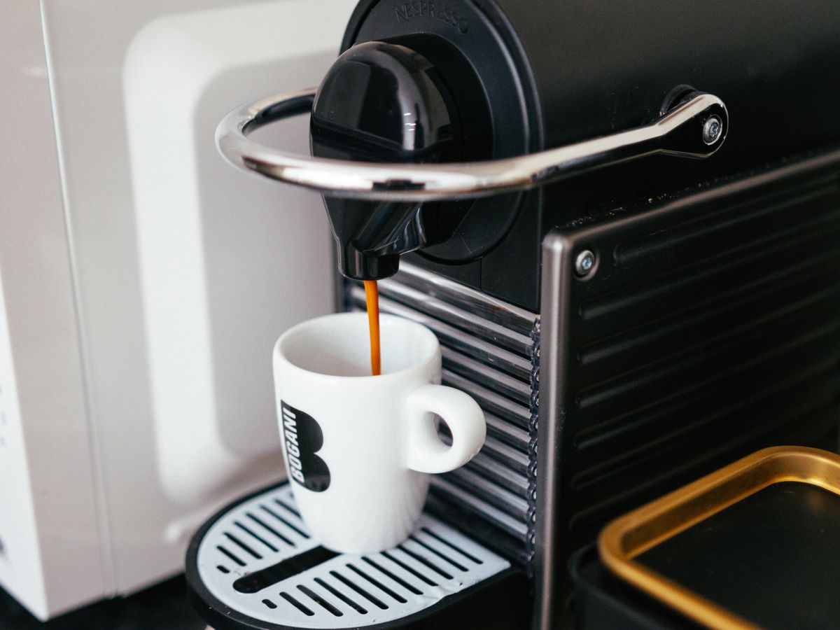 A modern espresso machine brewing a fresh shot into a brown cup
