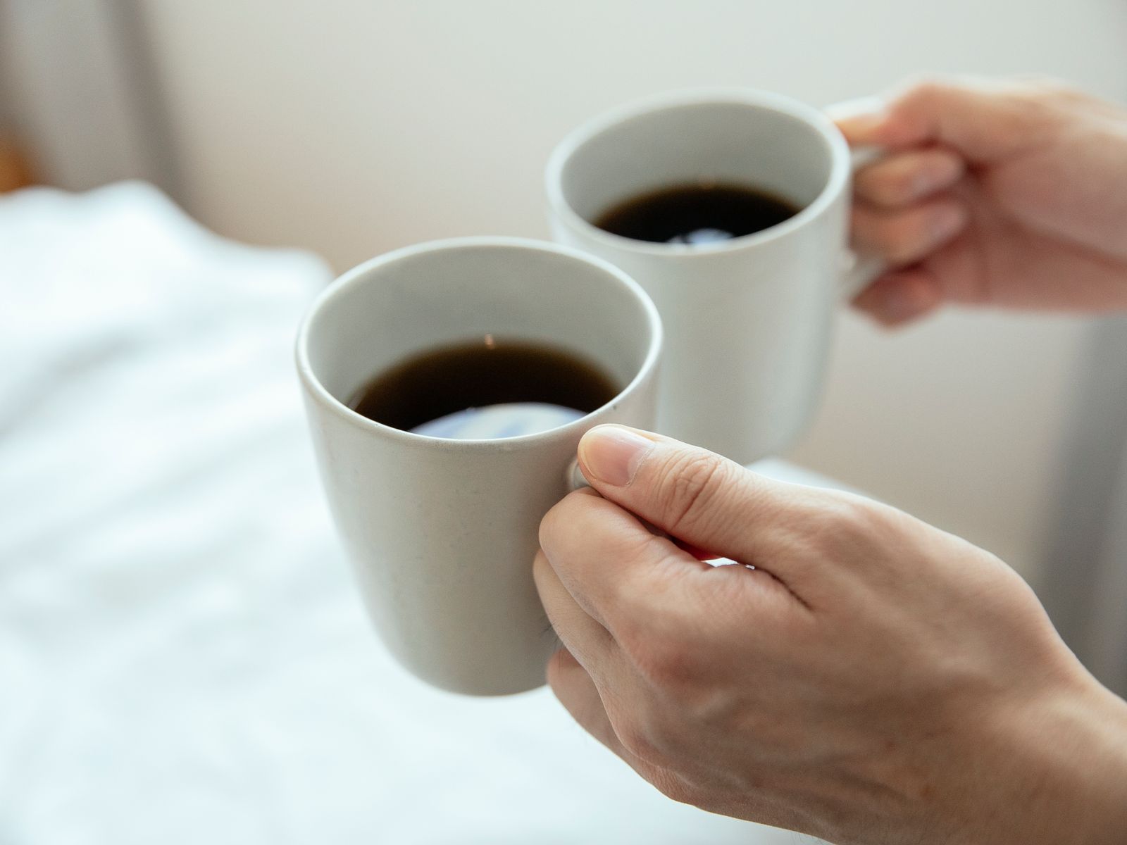 Hands cradling coffee at a comfortable drinking temperature
