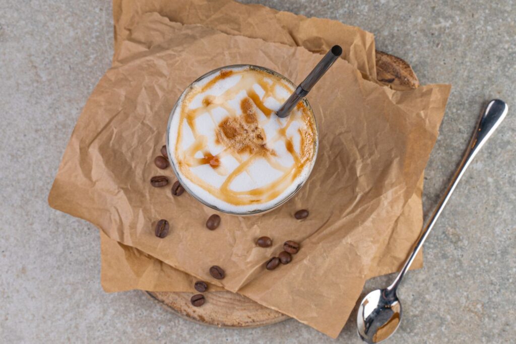 A cup of coffee topped with homemade coffee syrups and caramel drizzle