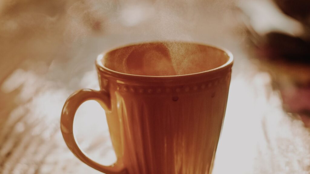 Keep coffee hot: a mug of coffee with steam rising, held at the right temperature