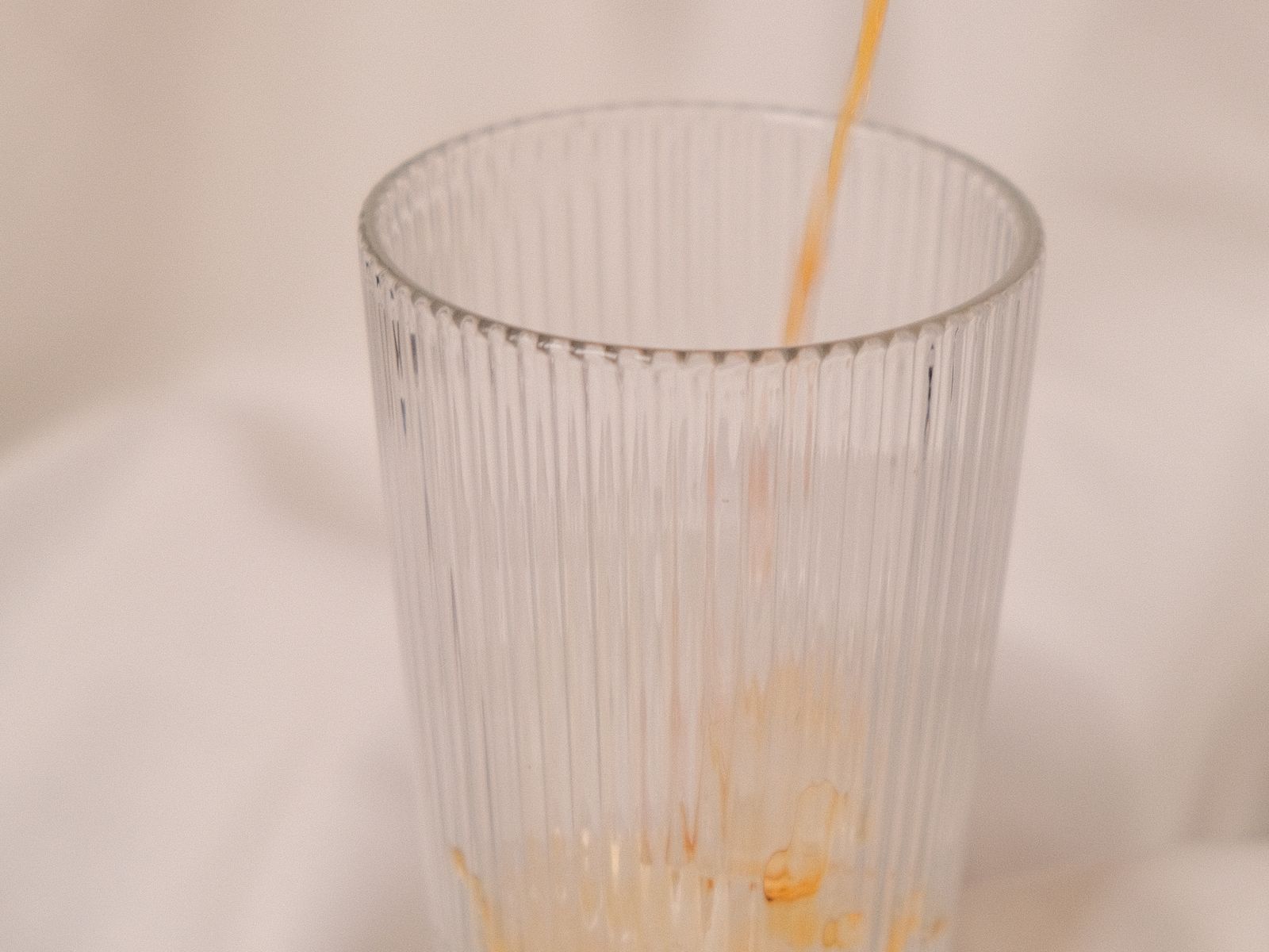 Pouring strong coffee over ice to build the base for iced coffee recipes
