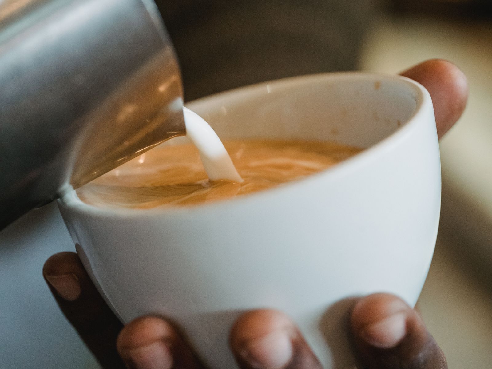 Pouring milk low and close to the surface, the key latte art motion to practice