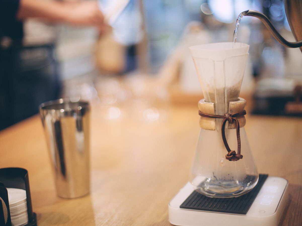 A drip kettle pouring water over coffee grounds